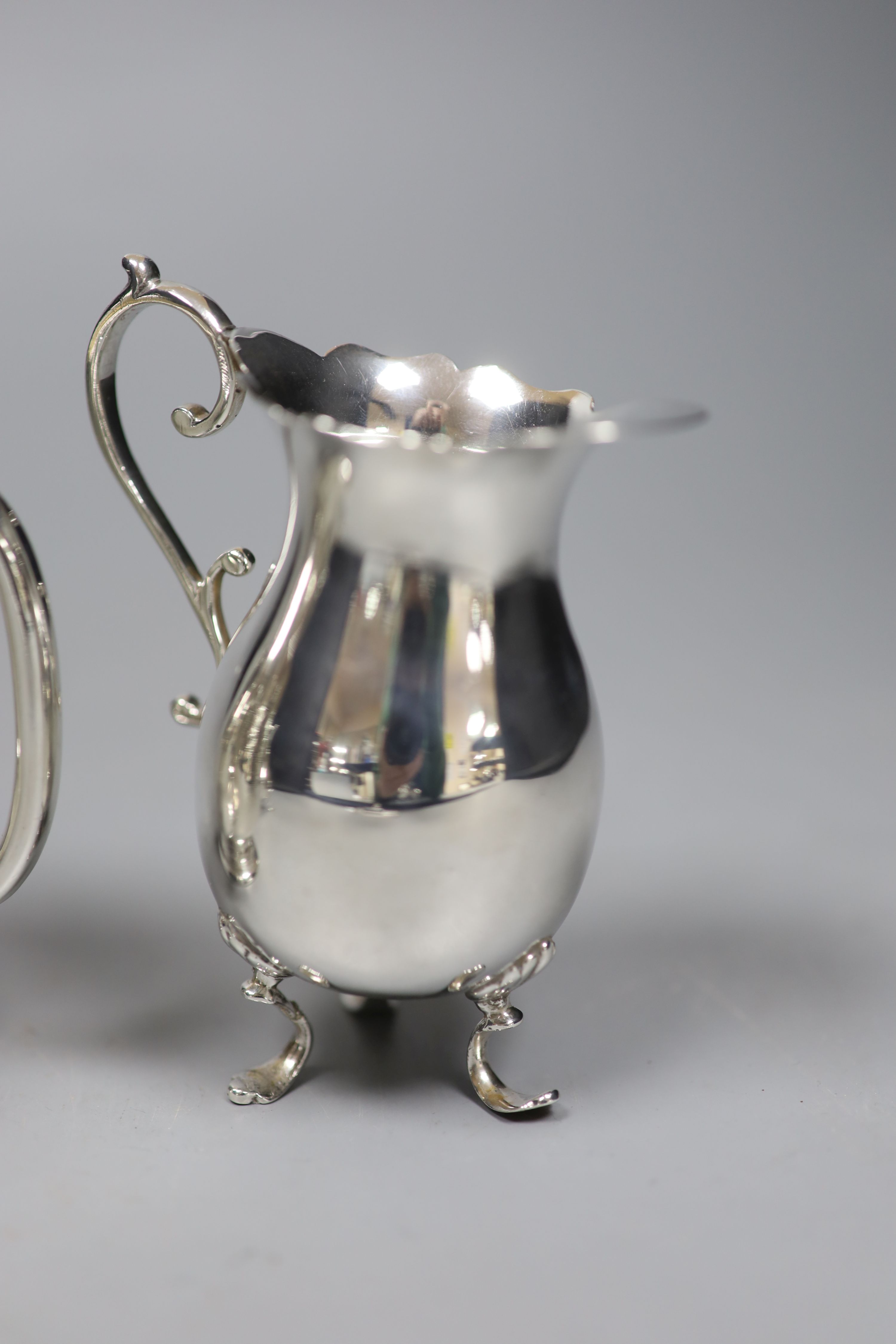 A Victorian engraved silver footed Christening mug and four silver cream jugs, various, 12.3 oz approx